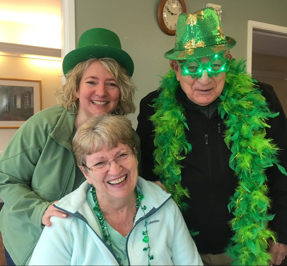 Photo of three smiling people dressed in green, celebrating St Patrick's day